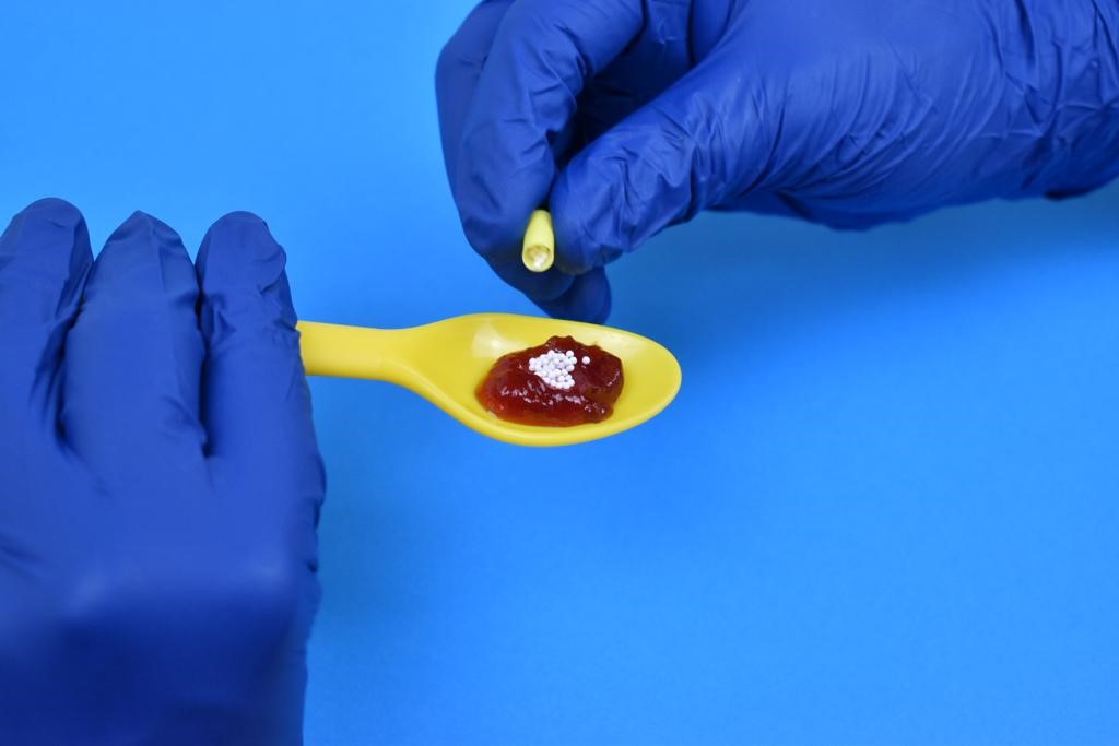 Shows a spoon of jam and the contents of the capsule being poured on top of the jam